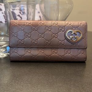 Gucci Guccisma leather wallet. Peach/beige in color with gold heart accent.